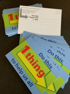 A stack of brightly colored postcards that say 'Do this 1 thing to help us all'