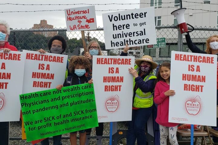 Group of volunteers holding Healthcare is a Human Right signs