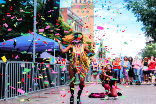 A person twirling under confetti getting their picture taken.